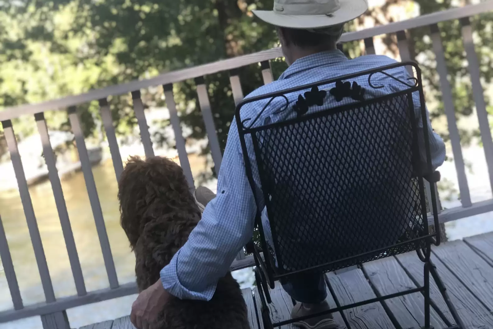 Man sitting with dog on porch