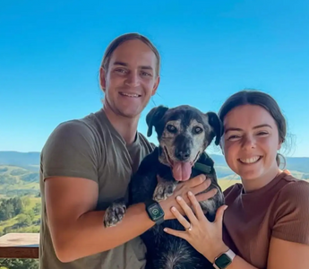 Dog posing with couple after proposal