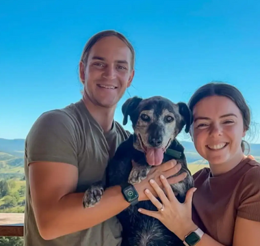 Dog posing with couple after proposal
