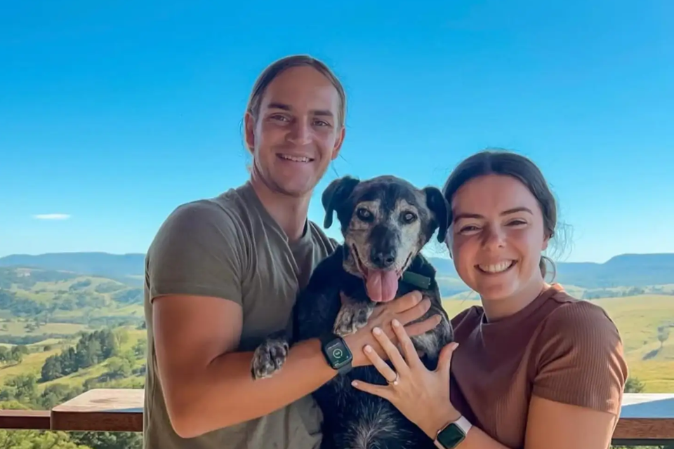 Dog posing with couple after proposal