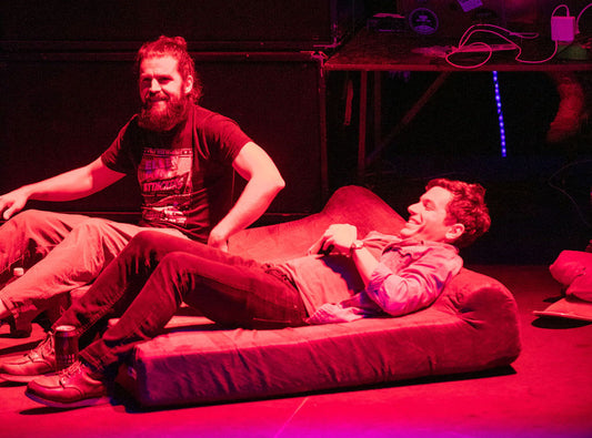 Two Dudes On a Stage Laying on Dog Beds
